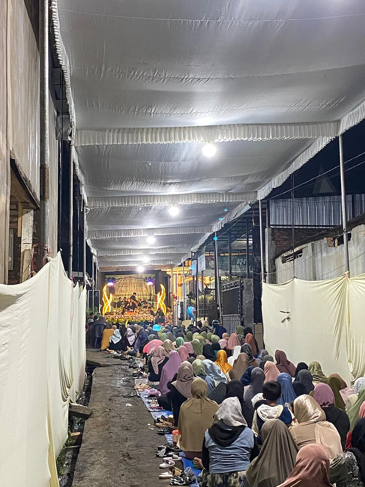 Foto contoh: warga duduk bersama berdoa di malam hari dalam sebuah acara pengajian umum.
